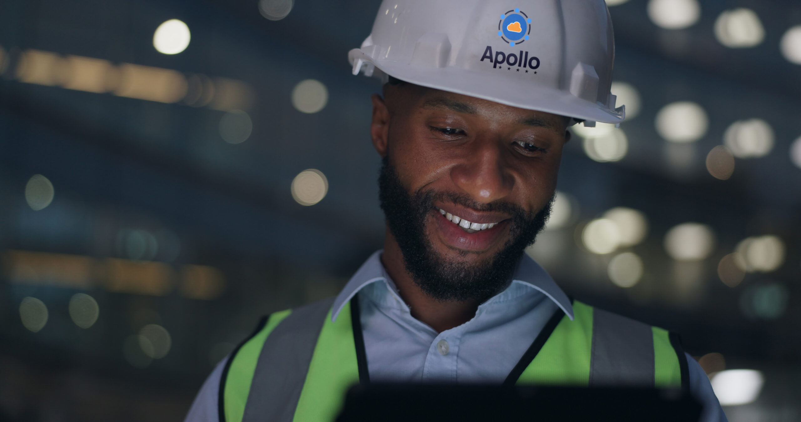 Female engineer wearing PPE at a data center construction site, looking at her tablet.