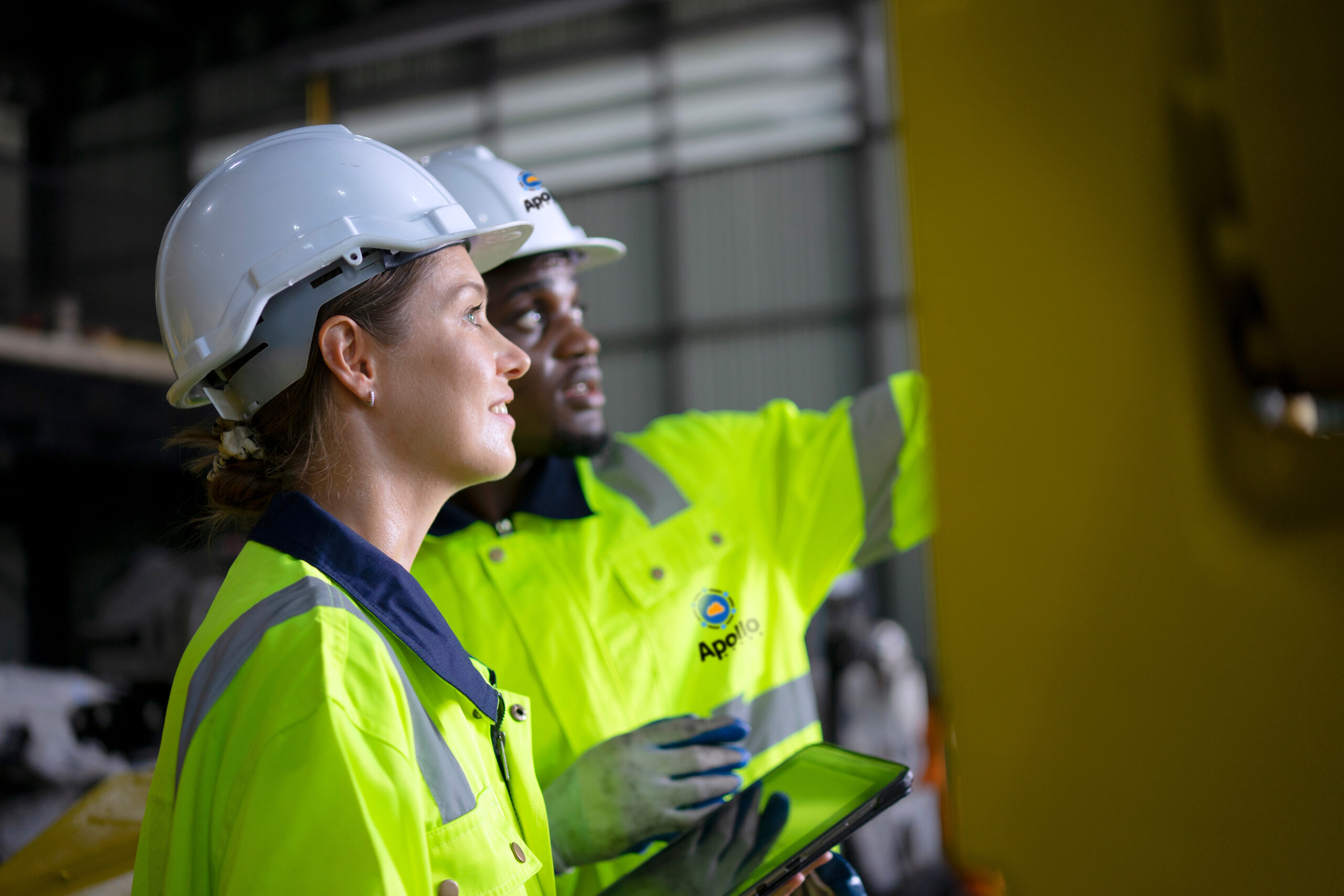 Male and female engineers working at data center construction site.